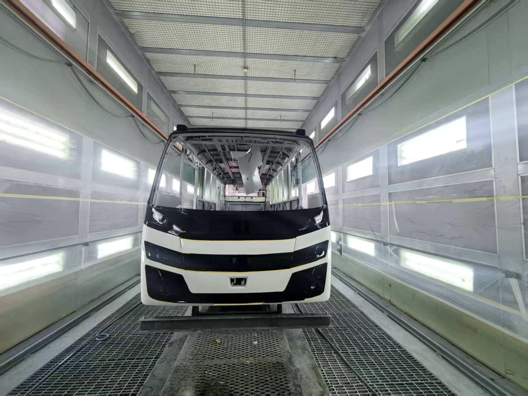 midibus eléctrico kinwin elite en una cabina de pintura ya terminado de pintar